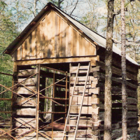 Log smokehouse nearly complete.