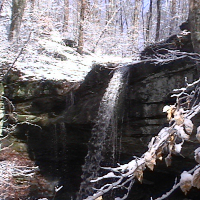 Water falling off snow covered bluff.